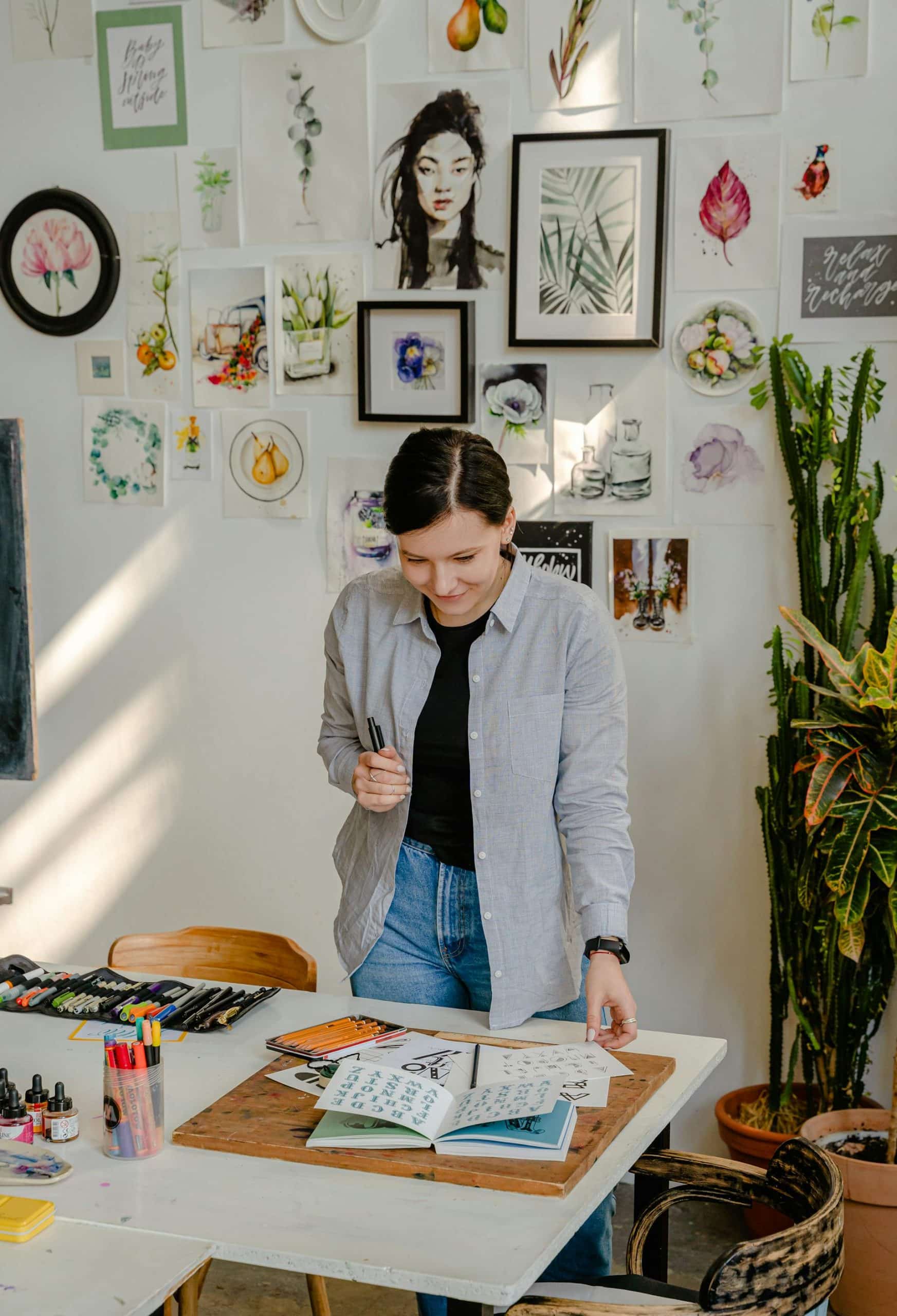 Young woman in a sunlit workspace, immersed in art surrounded by vibrant creativity and inspiration.