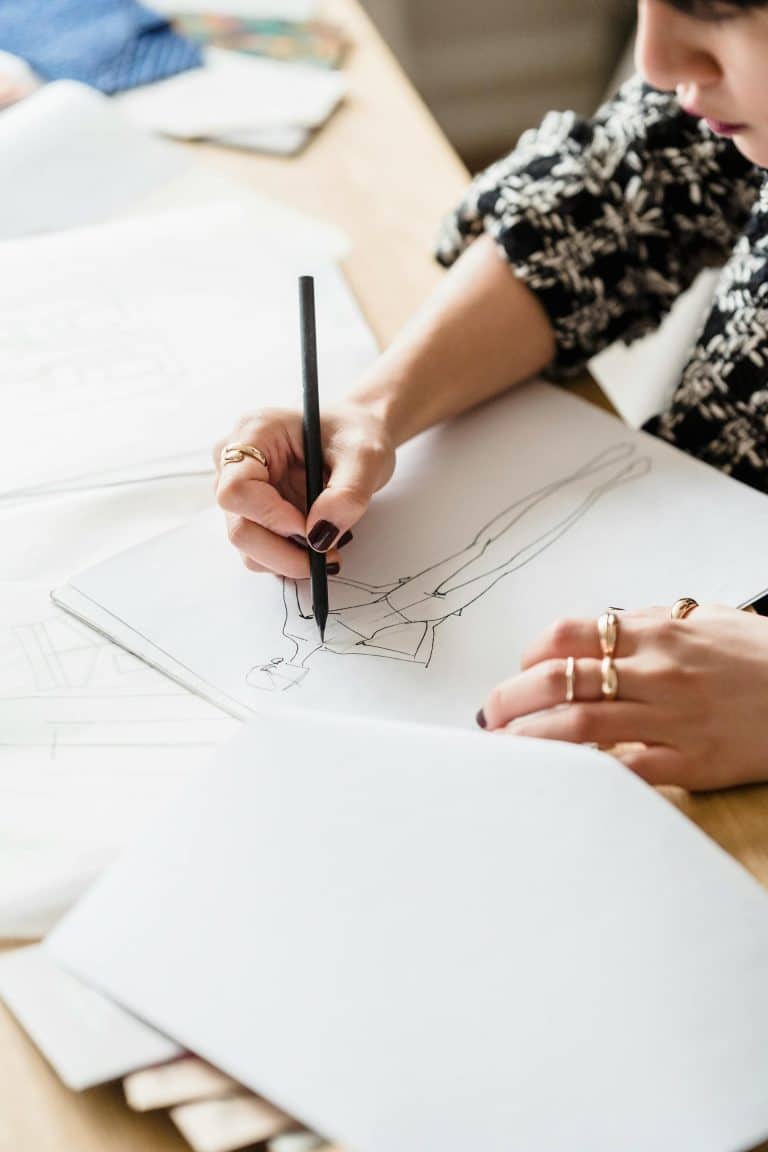 Artist sketching on paper, showcasing creativity and inspiration in a well-lit workspace.
