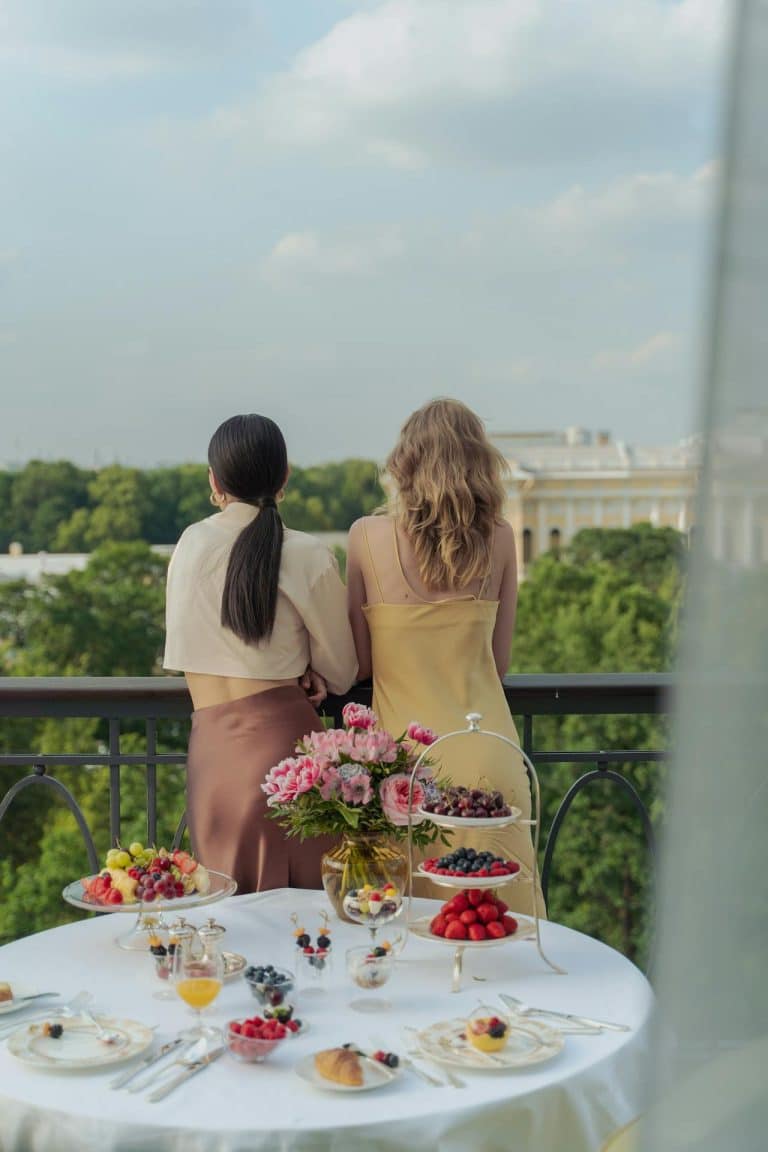 Women enjoying a stylish brunch on a balcony, surrounded by natures beauty and tranquility.