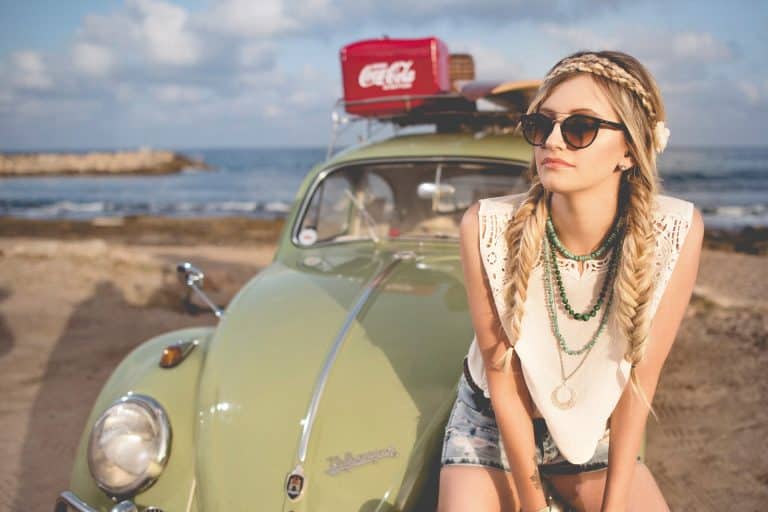 Summer beach scene with a vintage green Volkswagen Beetle and a bohemian woman ready for adventure.