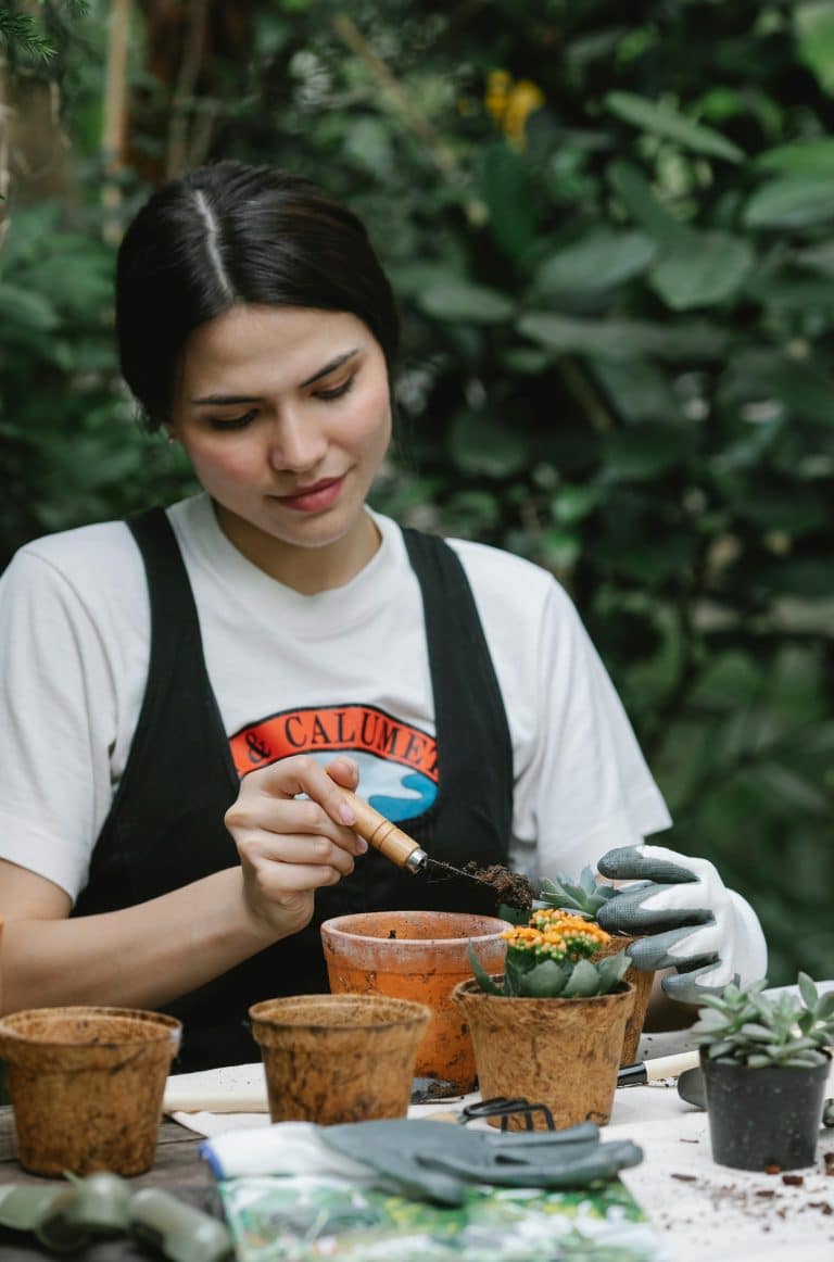 Young woman gardening in a vibrant indoor oasis, nurturing plants with care and focus.