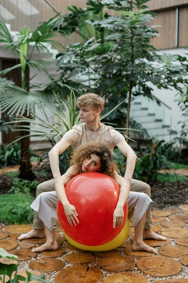 Playful interaction in a lush indoor garden, featuring vibrant plants and a striking red ball.