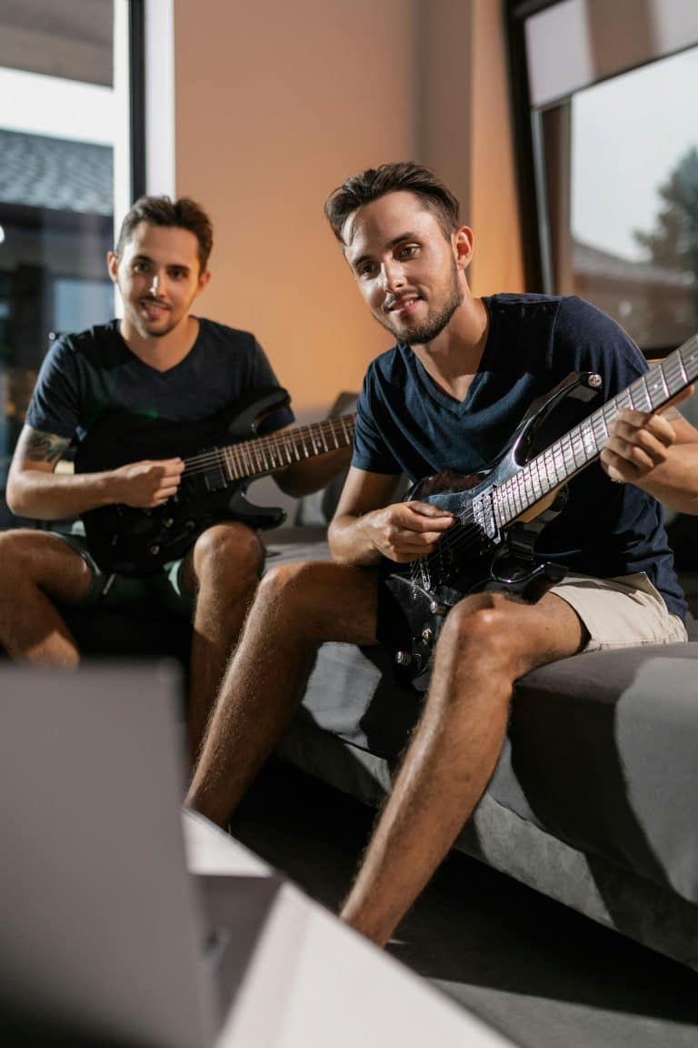Two men playing electric guitars indoors