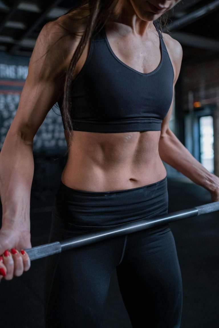 Strong woman lifting weights in stylish black workout gear, showcasing dedication and fitness.