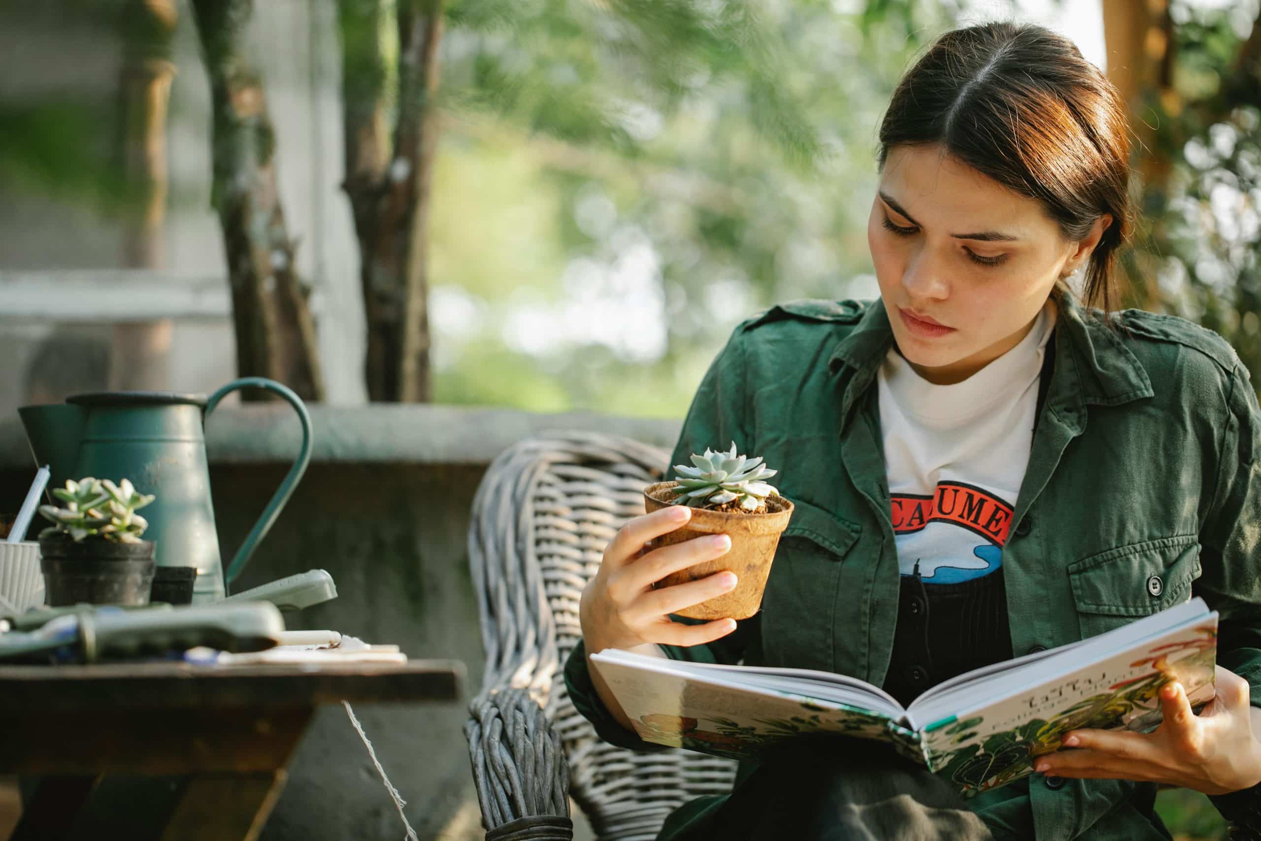 Young woman relaxing outdoors with succulents, enjoying nature and gardening inspiration.