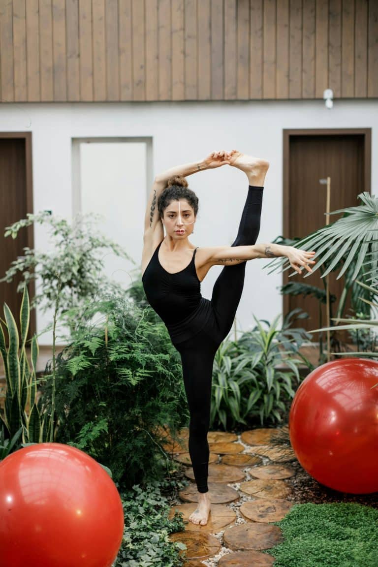 Impressive yoga pose amidst lush greenery in a serene indoor setting.