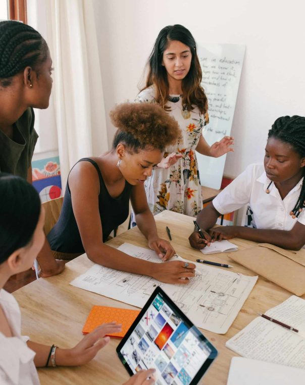Creative women collaborating in a vibrant brainstorming session around a wooden table.
