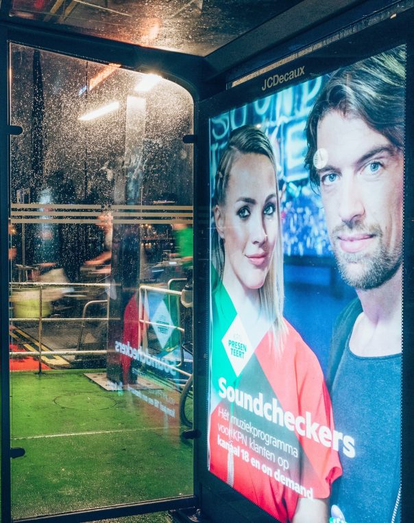 Modern bus shelter featuring dynamic Soundcheckers advertisement in a lively urban setting.