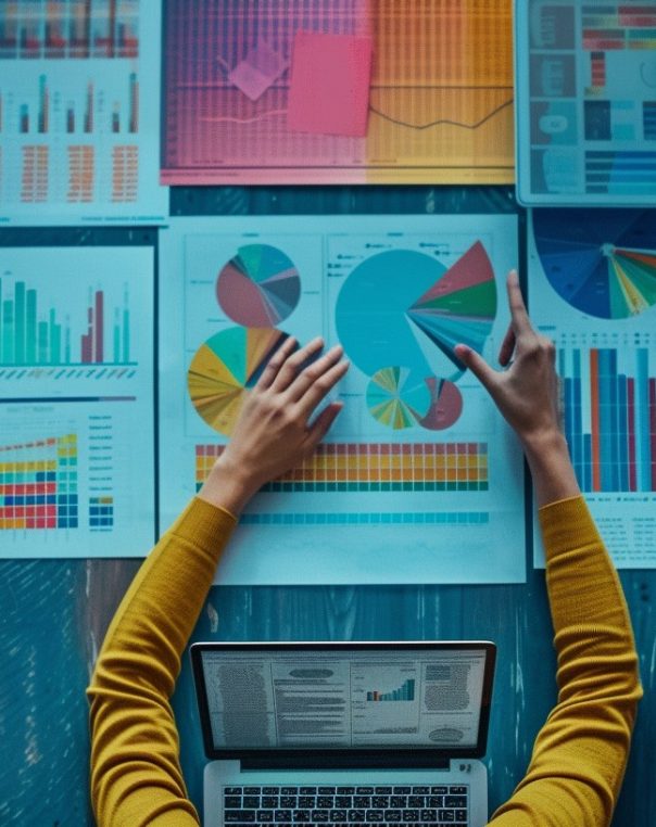Dynamic workspace showcasing colorful data visualizations and hands-on analysis with a laptop.