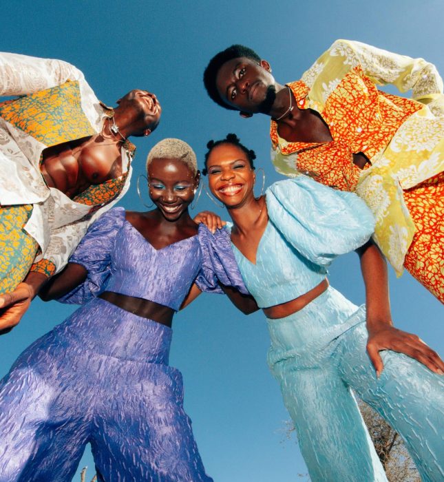 Colorful friends celebrate friendship and fashion under a bright blue sky on a sunny day.