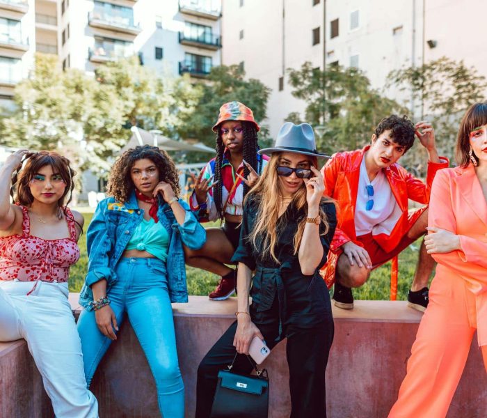 Stylish friends enjoy a vibrant outdoor gathering in the city, showcasing trendy fashion and camaraderie.