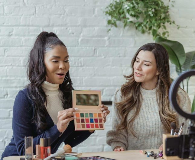 Friends collaborating in a bright makeup studio, sharing creativity and passion for beauty.