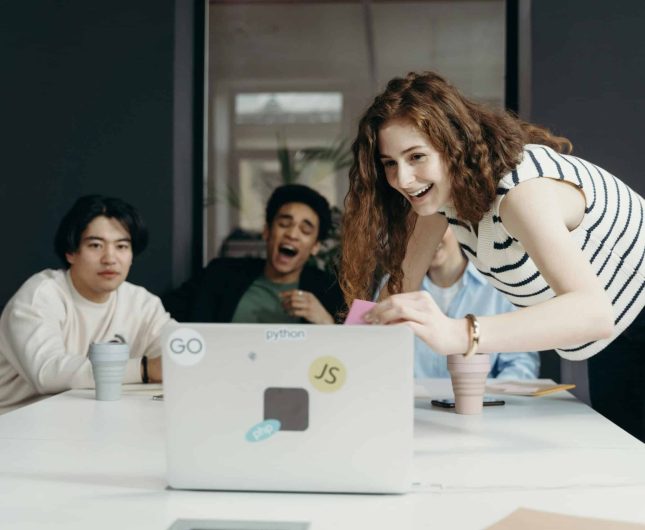 Vibrant team collaboration in a modern office, showcasing creativity and enthusiasm during a presentation.