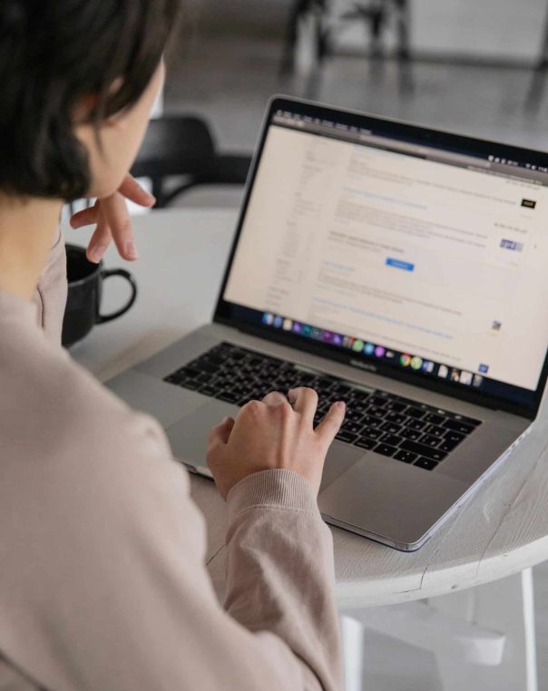 Individual focused on a laptop in a bright, modern workspace with relaxed ambiance.