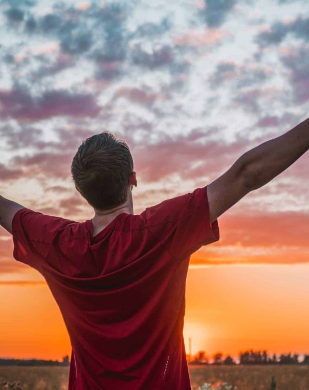 Joyful celebration at sunset in a vibrant field, embracing freedom and natureâ€™s beauty.