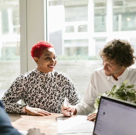 Lively discussion at a modern office table, showcasing collaboration and creativity among diverse professionals.