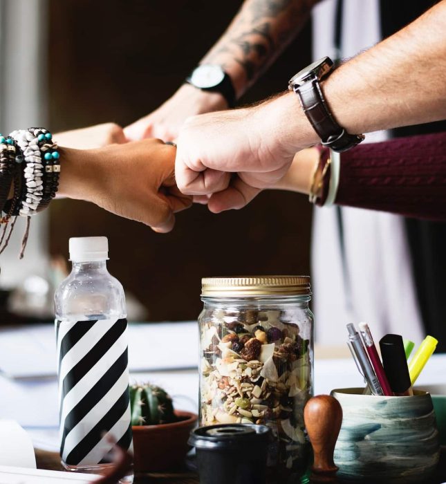 Team collaboration and camaraderie highlighted by a fist bump in a vibrant workspace.