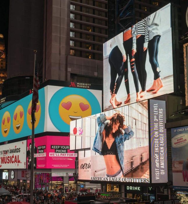 Vibrant Times Square billboards showcase active lifestyles and playful ads in a bustling urban scene.