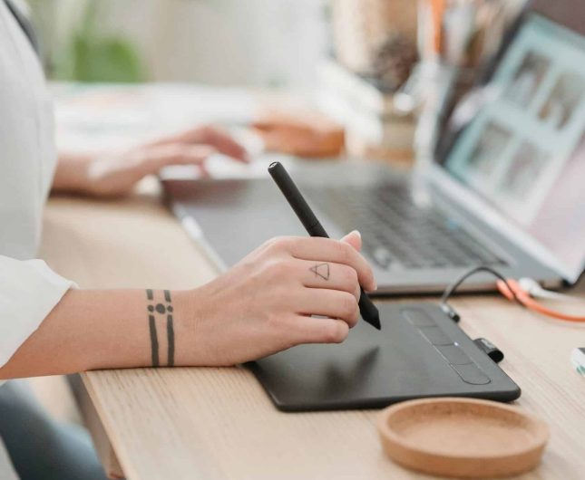 Artistic workspace with digital tablet, laptop, and greenery for creative inspiration and organization.
