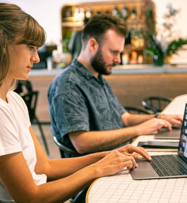 Young adults collaborate in a modern cafÃ© workspace, blending productivity with a relaxed atmosphere.