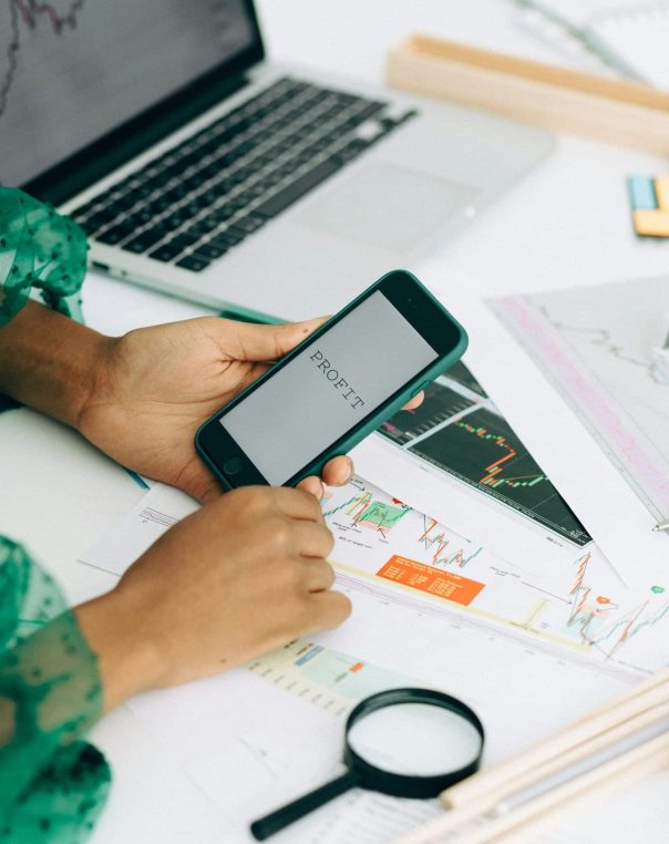 Analytical workspace with smartphone, charts, and laptop for efficient data analysis and insights.